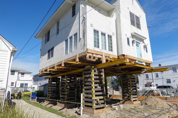 A team of professionals using specialized equipment to raise a house in Detroit, preparing it for elevation and renovation